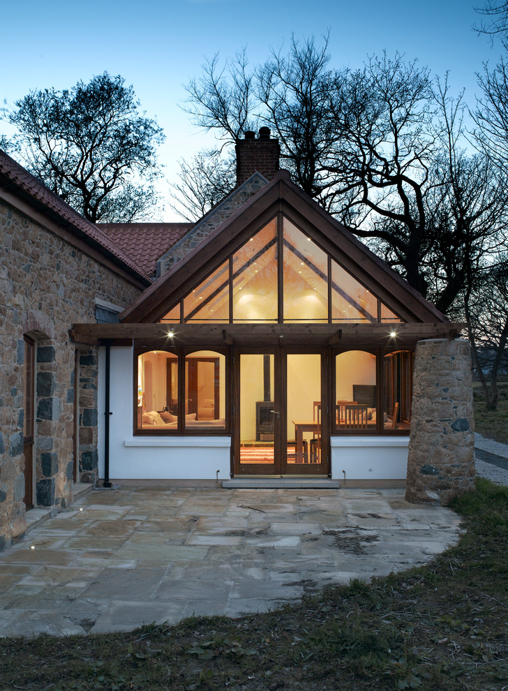 Country bungalow house exterior in Channel Islands with stone cladding.