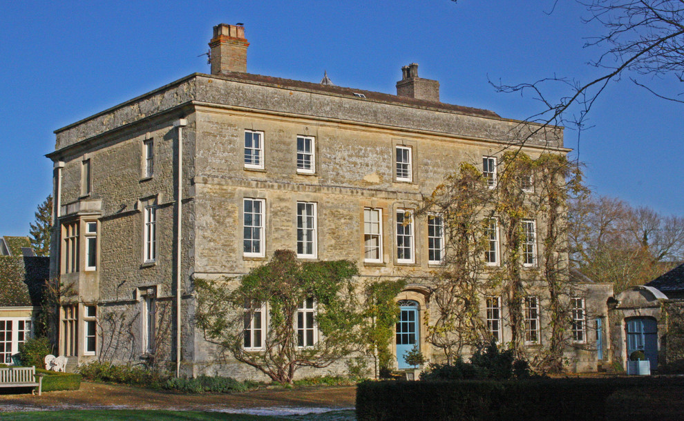 Exemple d'une grande façade de maison marron chic en pierre à deux étages et plus.
