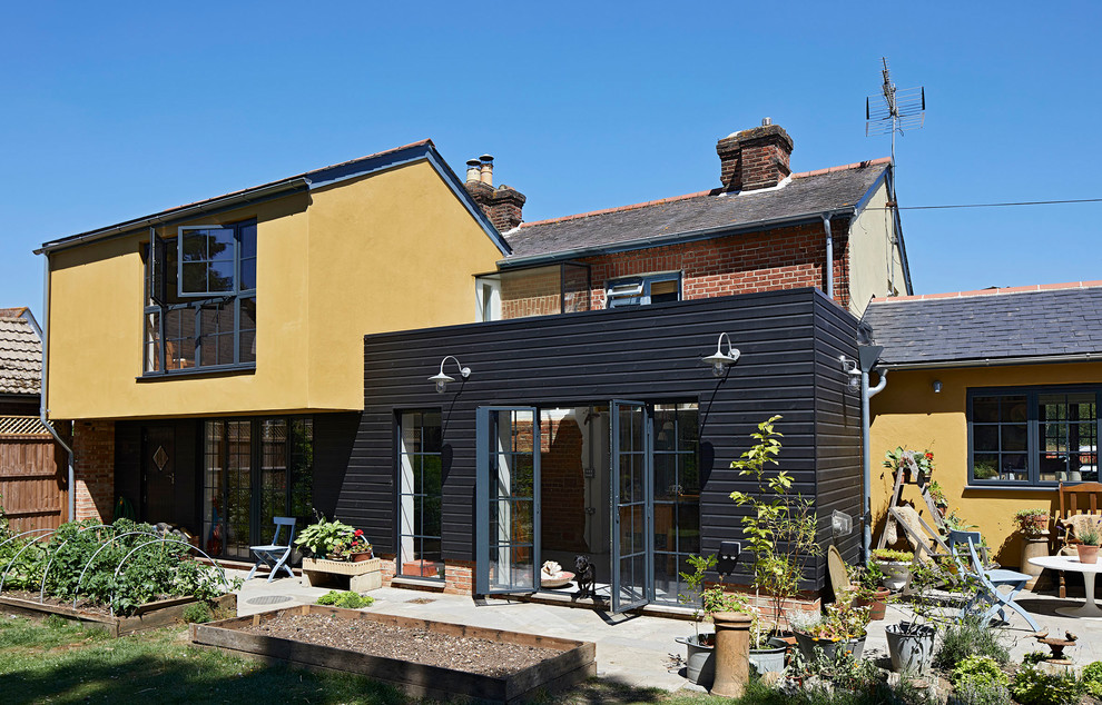 Medium sized and multi-coloured country two floor detached house in Hertfordshire with mixed cladding.