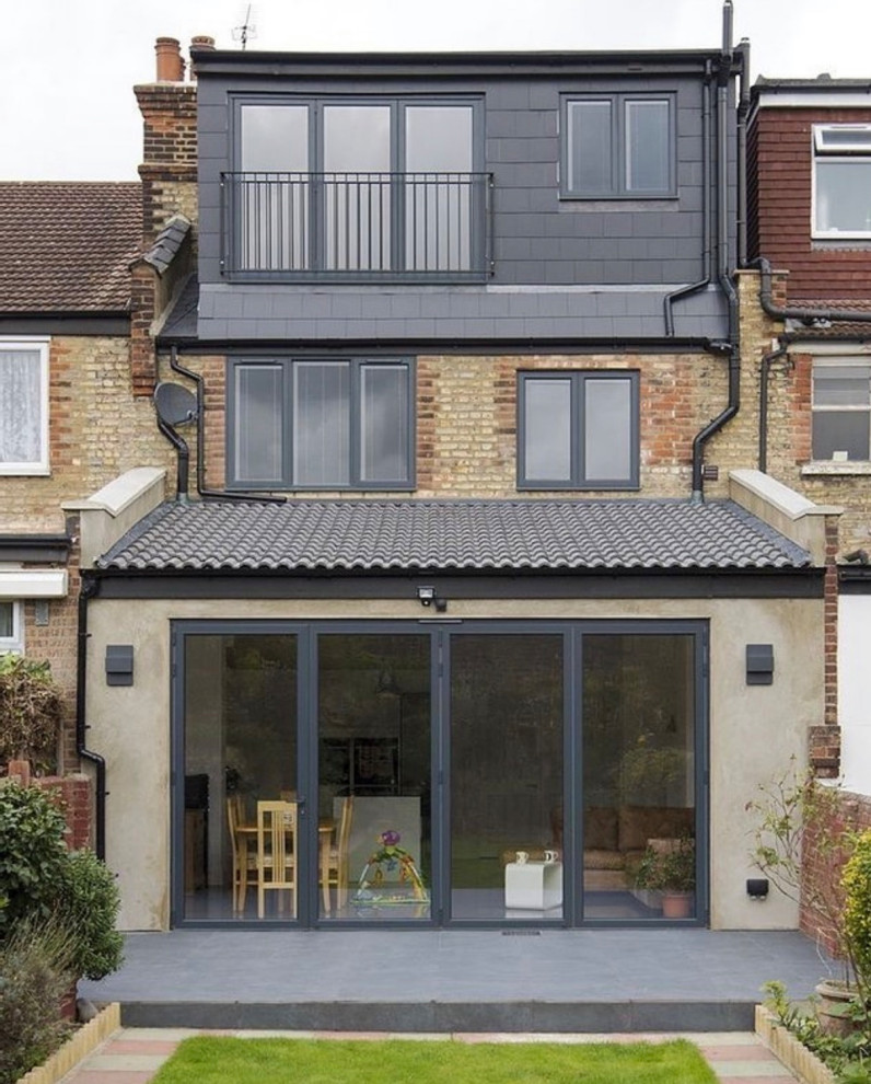 Ejemplo de fachada de casa pareada negra y negra minimalista grande de tres plantas con revestimientos combinados, tejado a cuatro aguas y tejado de teja de barro