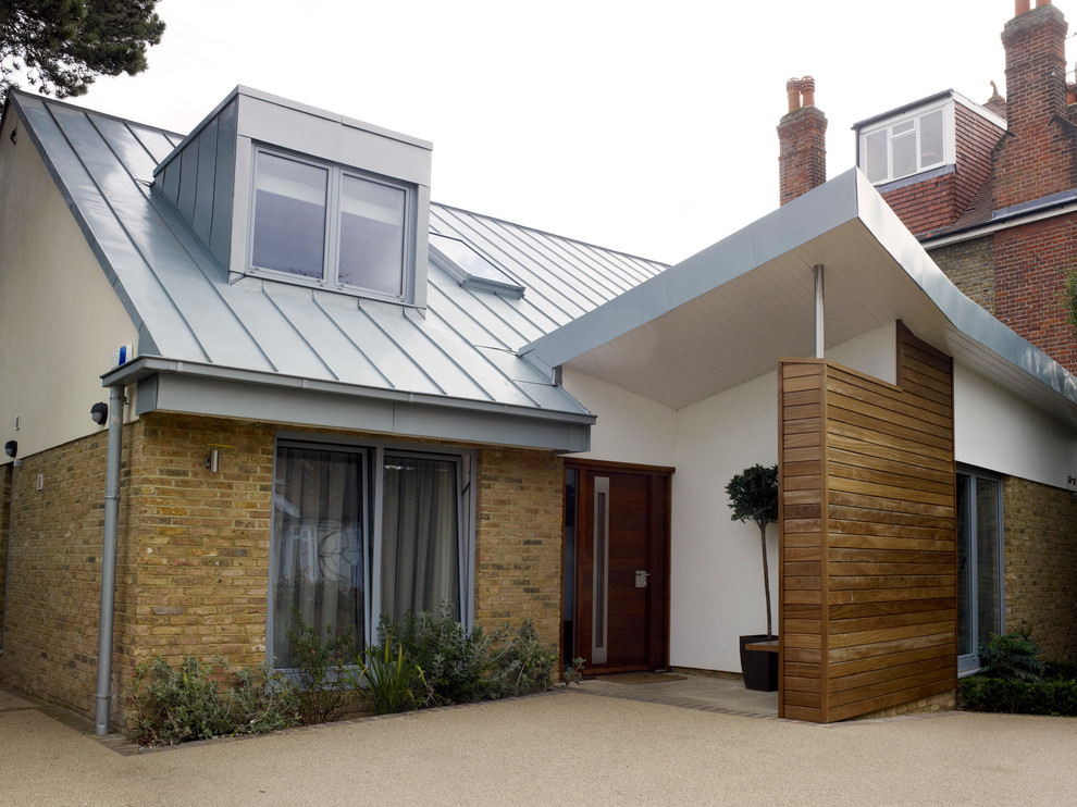 Photo of a medium sized and white contemporary two floor brick house exterior in London with a pitched roof.
