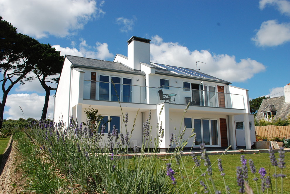 This is an example of a white contemporary two floor render and rear house exterior in Cornwall.