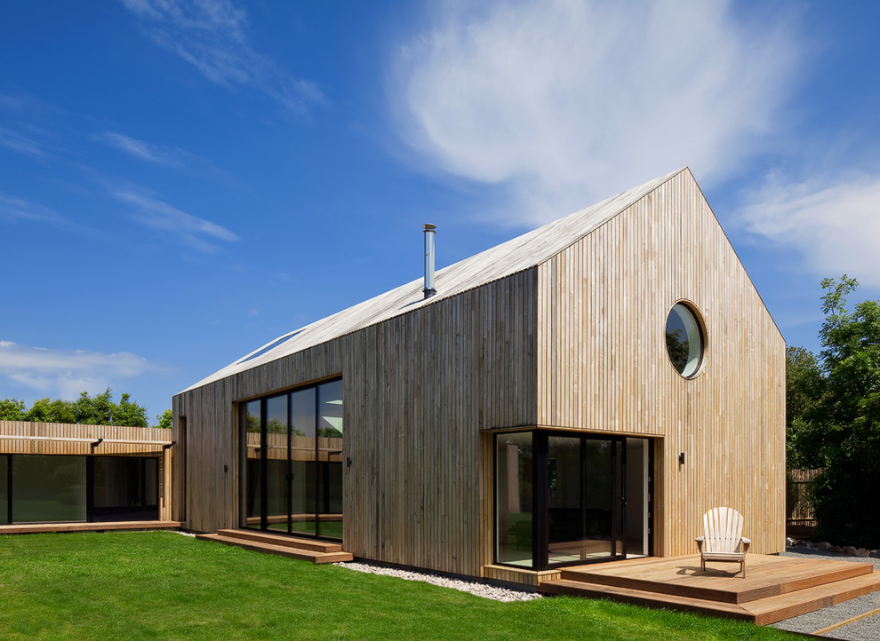Diseño de fachada contemporánea de una planta con revestimiento de madera y tejado a dos aguas