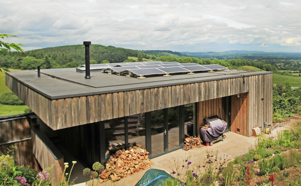 Diseño de fachada de casa marrón minimalista de tres plantas con revestimiento de madera y tejado plano