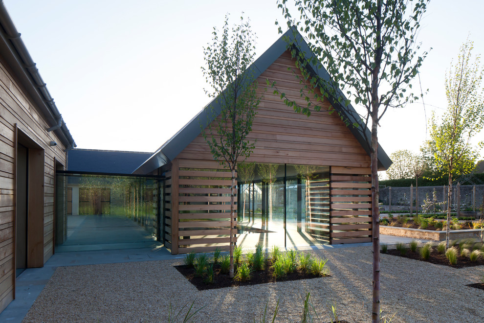 Immagine della facciata di una casa contemporanea con rivestimento in legno e tetto a capanna