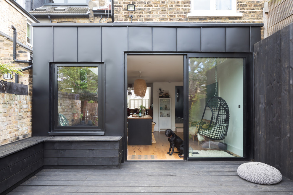 Medium sized and black contemporary terraced house in London with metal cladding.