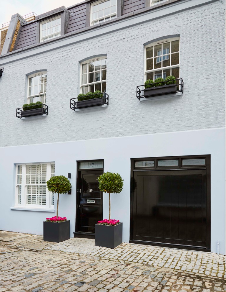 Modelo de fachada gris clásica renovada de tamaño medio de tres plantas con revestimientos combinados