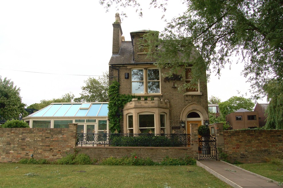 Immagine della facciata di una casa grande beige classica con rivestimento in mattoni