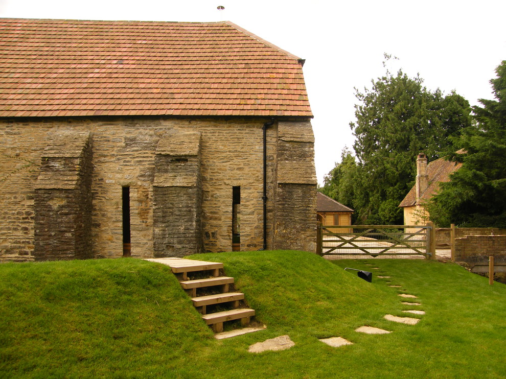 Esempio della facciata di una casa grande country a due piani con rivestimento in pietra e tetto a padiglione