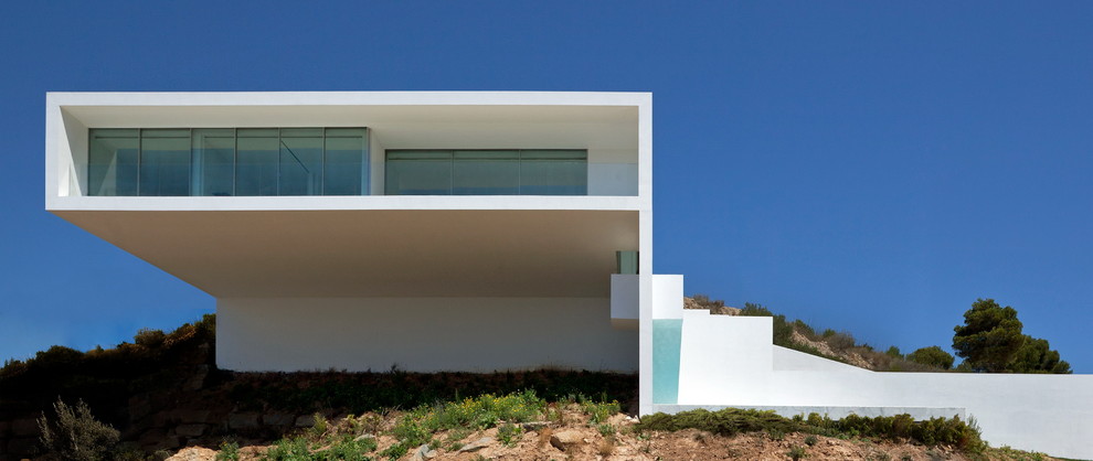 Стильный дизайн: большой, белый дом в стиле модернизм с плоской крышей - последний тренд