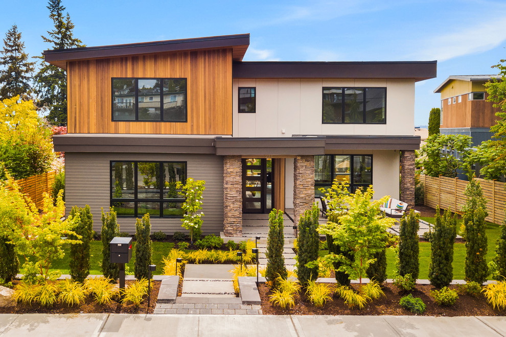На фото: разноцветный, двухэтажный частный загородный дом в стиле ретро с комбинированной облицовкой и односкатной крышей