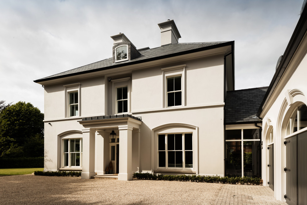Großes, Dreistöckiges Klassisches Einfamilienhaus mit Putzfassade, beiger Fassadenfarbe, Walmdach und Schindeldach in Surrey