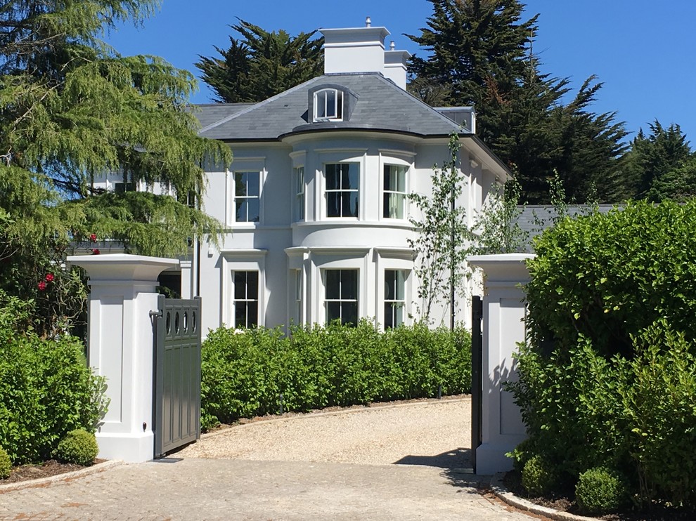 Großes, Dreistöckiges Klassisches Einfamilienhaus mit Putzfassade, beiger Fassadenfarbe, Walmdach und Schindeldach in Surrey