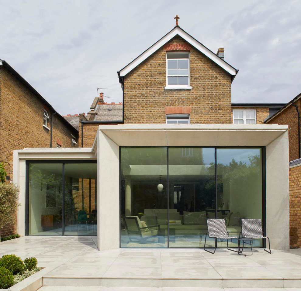 Contemporary concrete semi-detached house in London with three floors and a pitched roof.