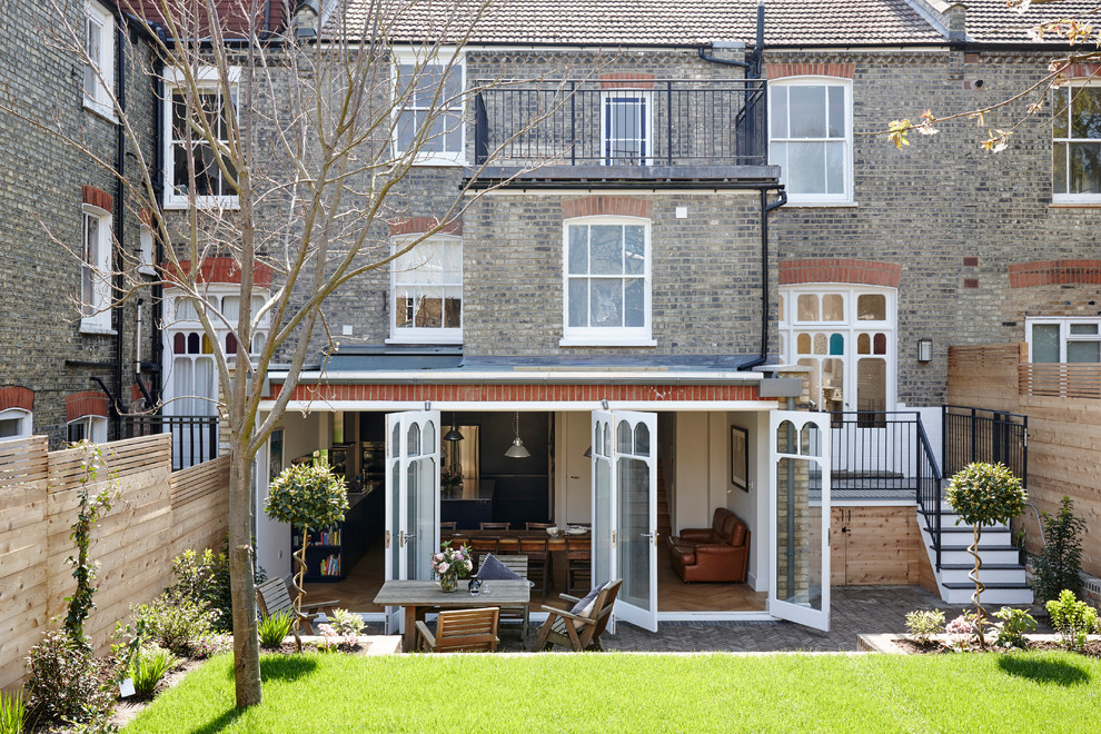 Inspiration for a medium sized and gey eclectic brick house exterior in London with three floors.