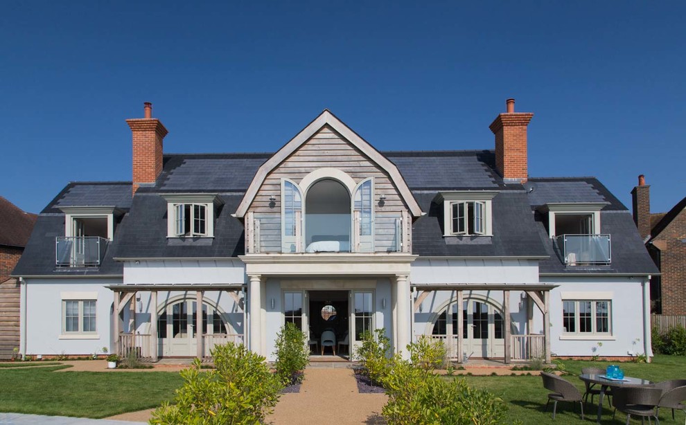 Idee per la villa blu stile marinaro a due piani con tetto a mansarda e copertura a scandole