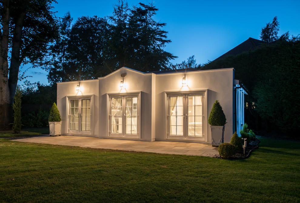 Свежая идея для дизайна: белый дом в стиле неоклассика (современная классика) с облицовкой из цементной штукатурки, вальмовой крышей и крышей из гибкой черепицы - отличное фото интерьера