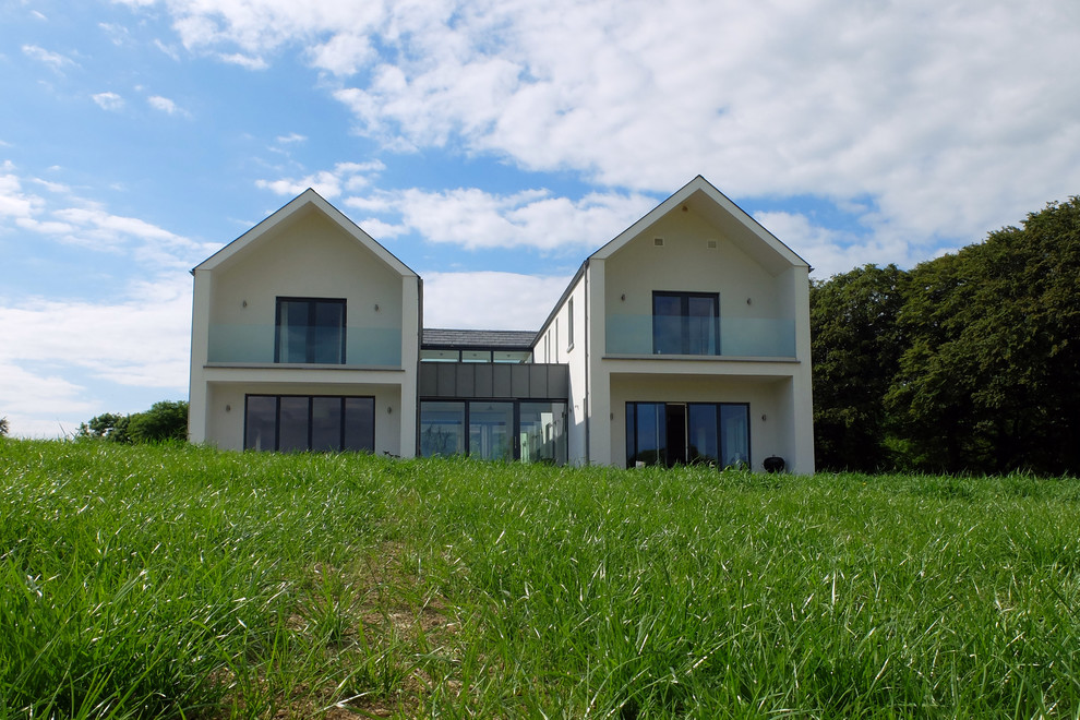 Photo of a large and white contemporary two floor house exterior in Cork with a hip roof.