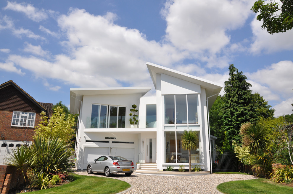 Design ideas for a white contemporary two floor house exterior in London with a lean-to roof.