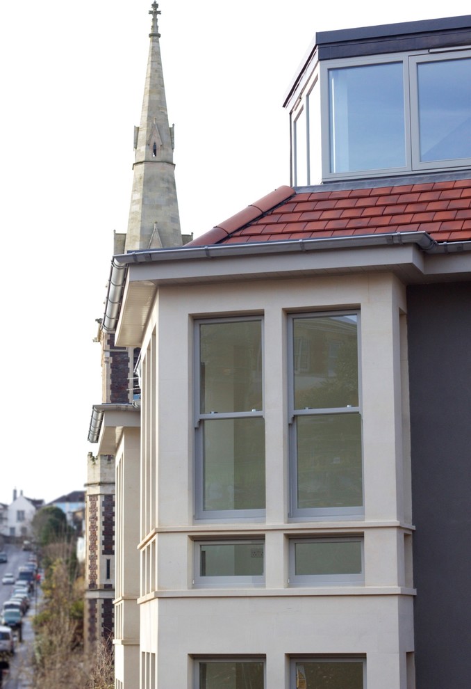 Esempio della facciata di una casa grigia classica a tre piani di medie dimensioni con tetto a padiglione