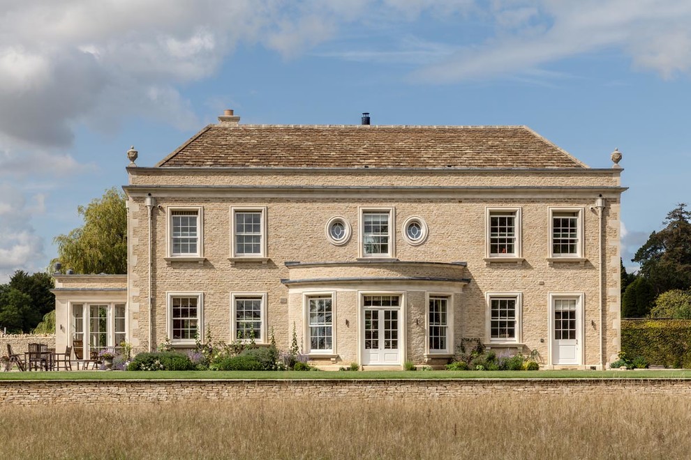 Photo of a beige traditional detached house in Gloucestershire with stone cladding and a pitched roof.