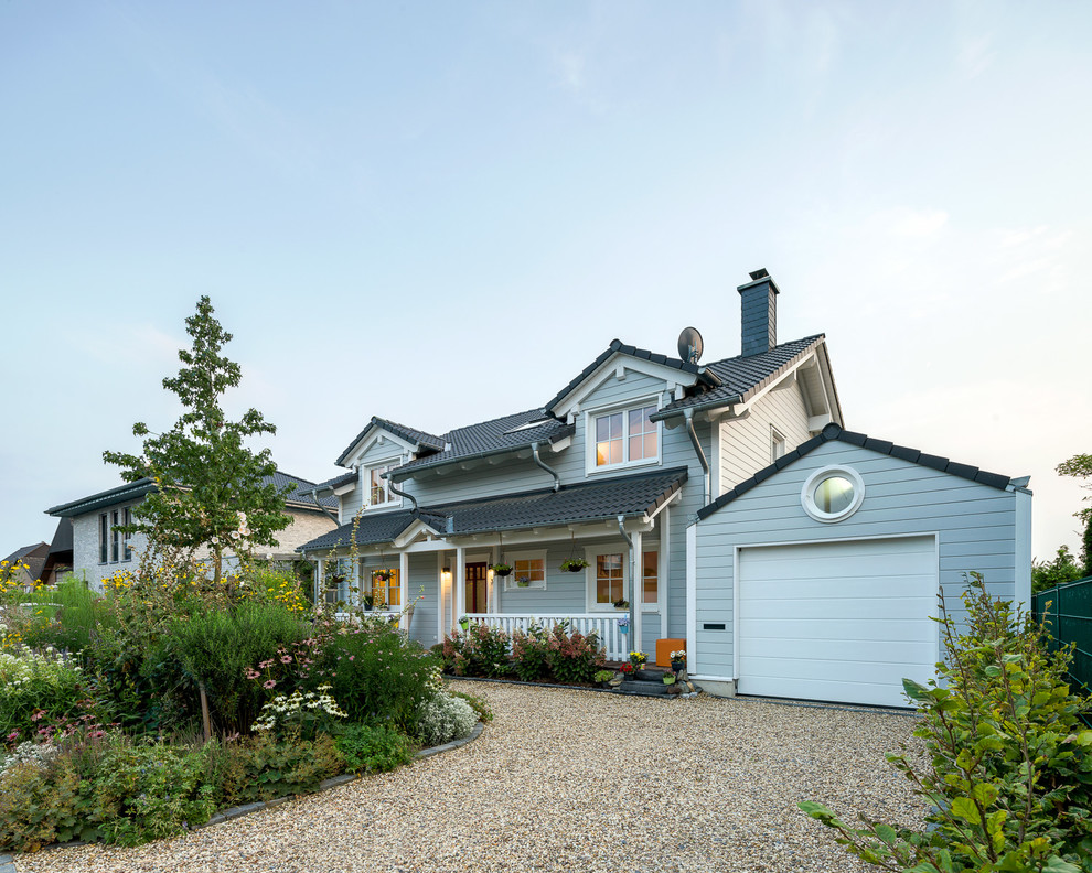 Exemple d'une façade de maison grise nature en bois de taille moyenne et à un étage avec un toit à deux pans et un toit en tuile.