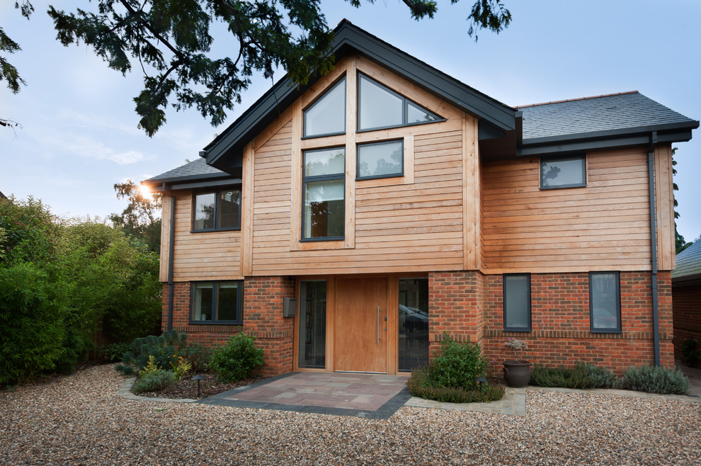Brown rustic two floor detached house in Berkshire with wood cladding and a pitched roof.