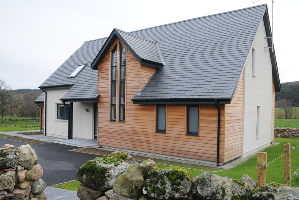 Idée de décoration pour une façade de maison multicolore design en bois de taille moyenne et à un étage avec un toit à deux pans et un toit en tuile.