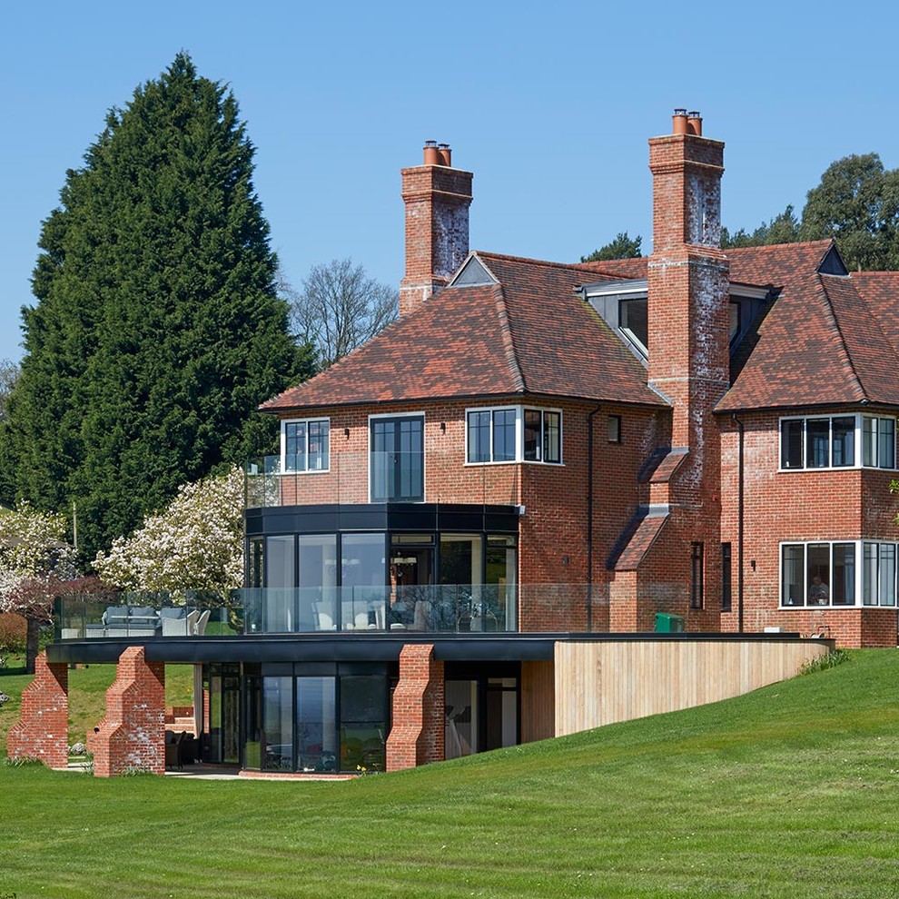 Inspiration for a red classic brick detached house in Surrey with three floors and a hip roof.