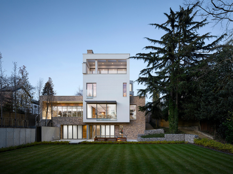 Стильный дизайн: большой, трехэтажный дом в современном стиле с комбинированной облицовкой и плоской крышей - последний тренд