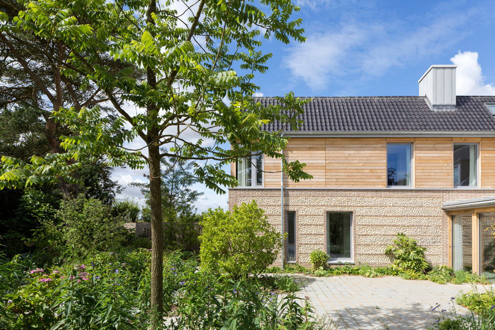 Imagen de fachada de casa de estilo de casa de campo grande de dos plantas con tejado a dos aguas, tejado de teja de barro y revestimiento de piedra