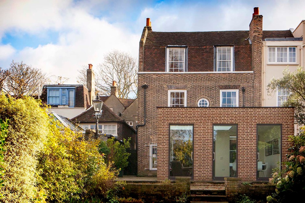 Inspiration for a red classic brick and rear extension in London with three floors.
