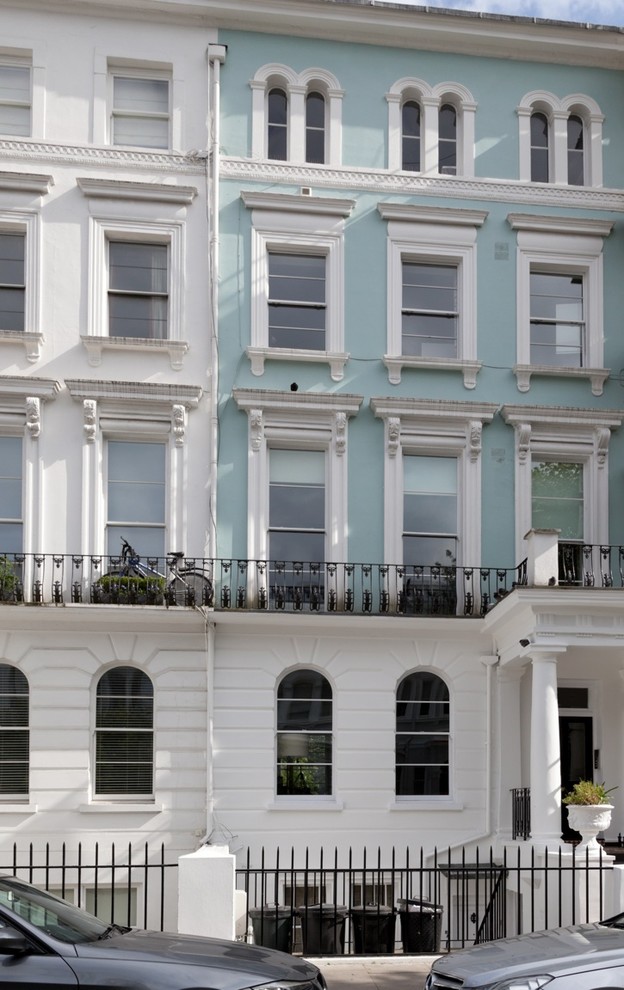 Esempio della facciata di un appartamento grande blu vittoriano a due piani con rivestimento in stucco, tetto piano e copertura in metallo o lamiera