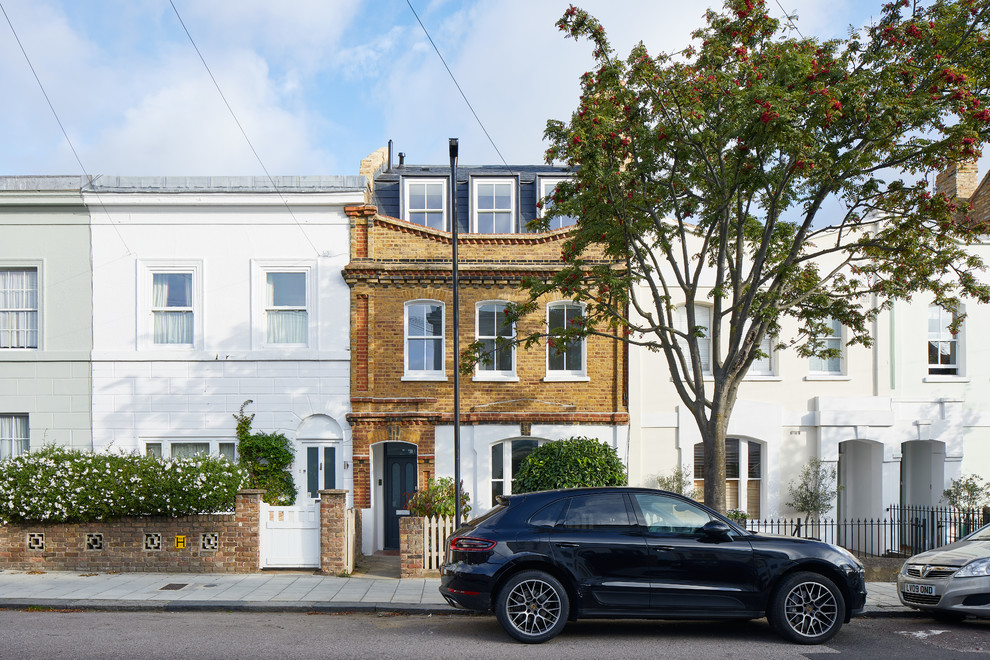 This is an example of a medium sized and brown traditional brick terraced house in London with three floors and a mixed material roof.