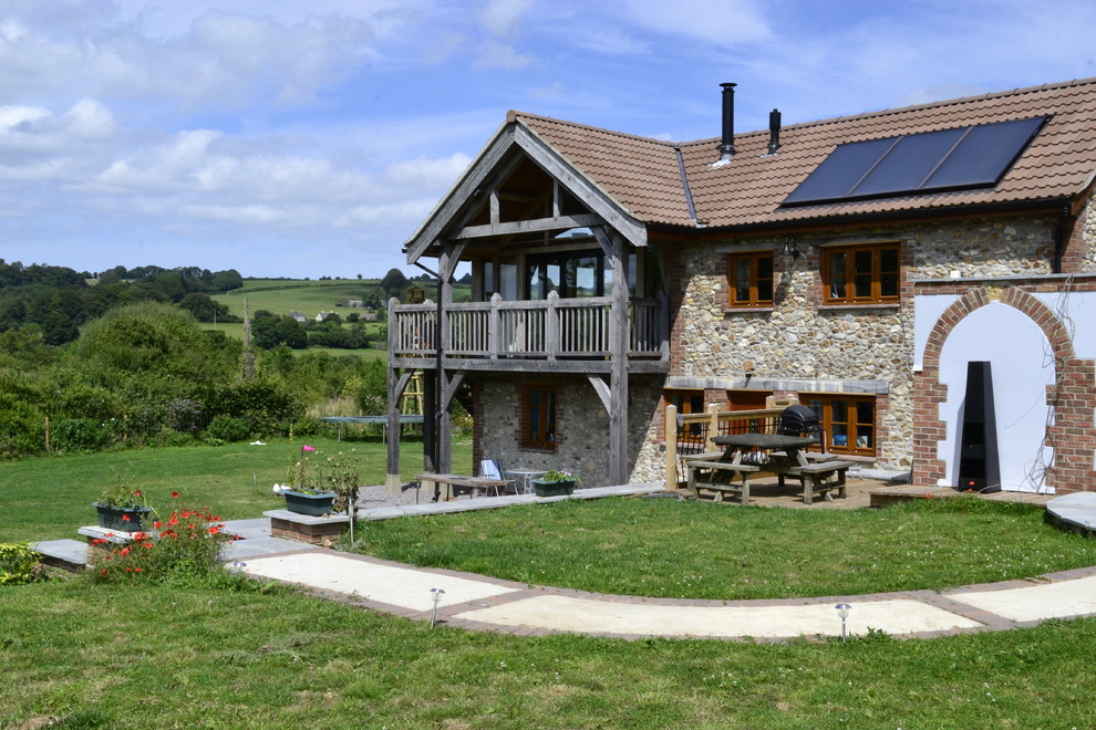 Diseño de fachada beige rural de tamaño medio de dos plantas con revestimiento de piedra y tejado a dos aguas