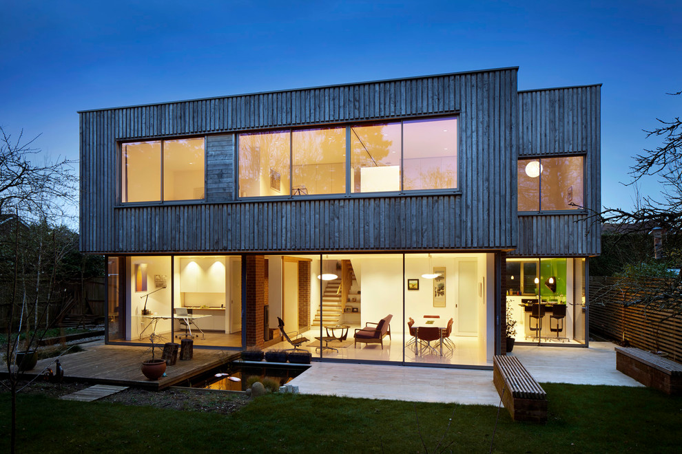 Medium sized modern two floor house exterior in London with wood cladding and a flat roof.