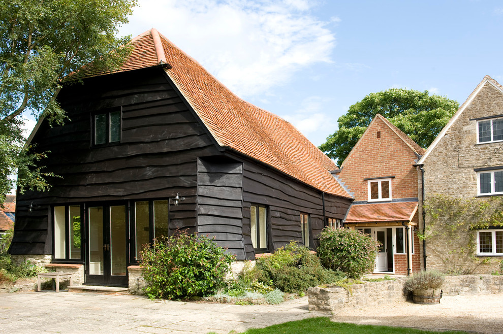 Foto de fachada de estilo de casa de campo grande de tres plantas con revestimientos combinados y tejado a la holandesa