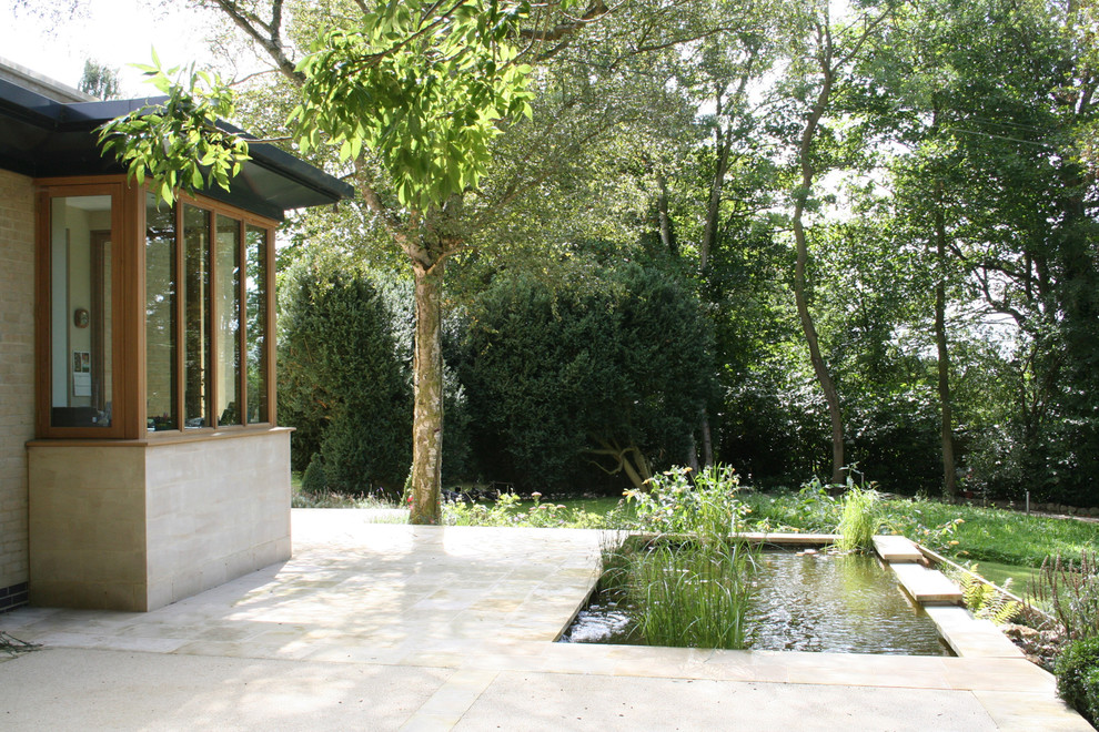Inspiration for a contemporary stone flat roof remodel in London