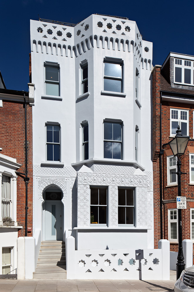Dreistöckiges Mediterranes Haus mit weißer Fassadenfarbe und Flachdach in London