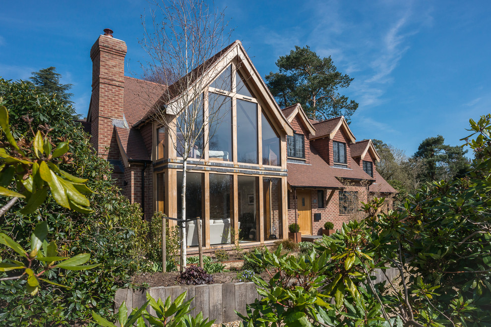 Diseño de fachada campestre grande de dos plantas con revestimiento de madera, tejado a dos aguas y tejado de teja de barro