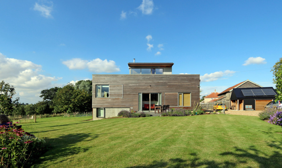 Inspiration pour une façade de maison grise design en bois à niveaux décalés avec un toit plat et un toit végétal.