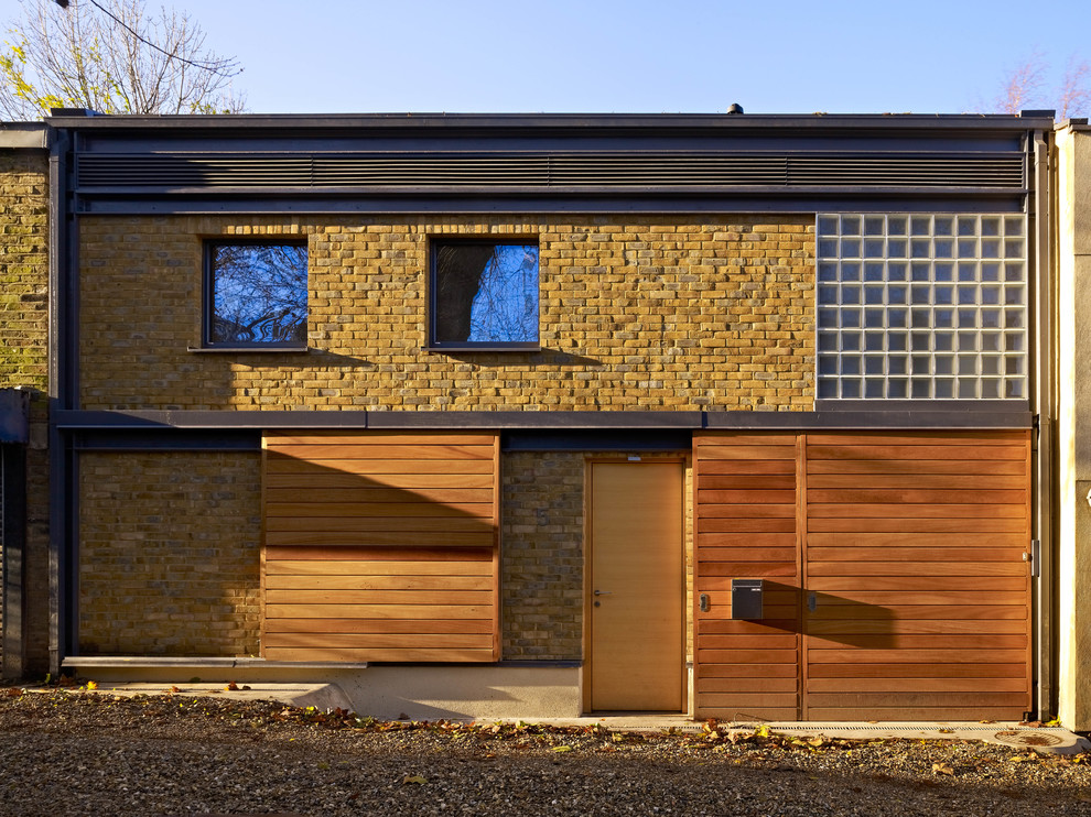 Cette image montre une façade de maison marron design à un étage et de taille moyenne avec un revêtement mixte et un toit plat.