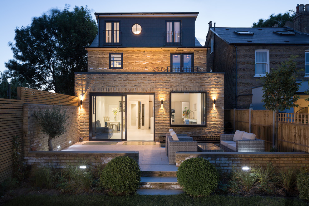 Large and beige classic split-level brick house exterior in London.