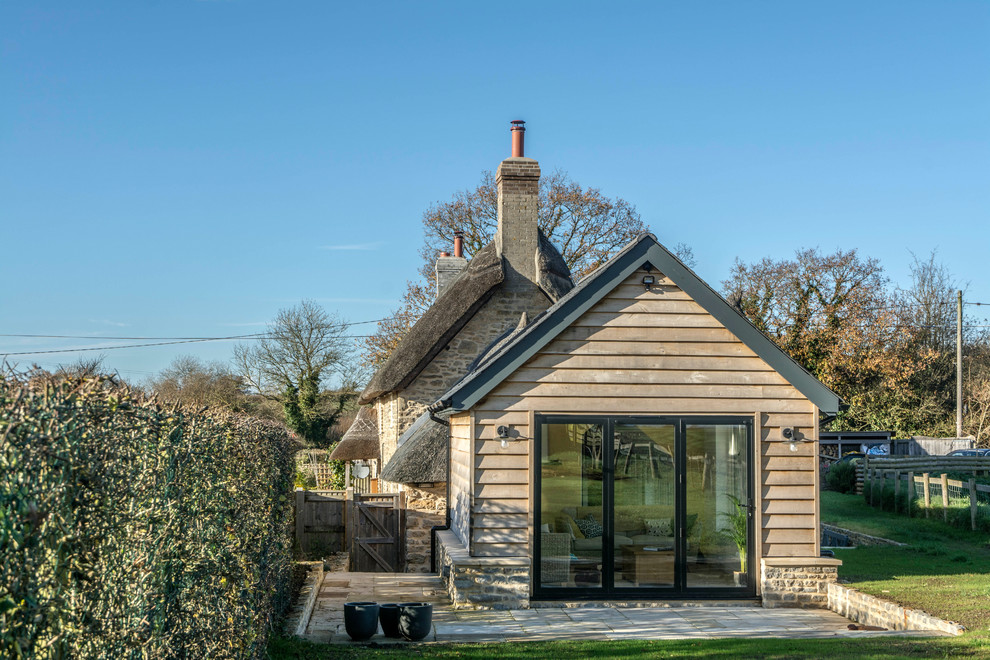 Mittelgroßes Landhausstil Haus mit beiger Fassadenfarbe, Satteldach und Misch-Dachdeckung in Dorset