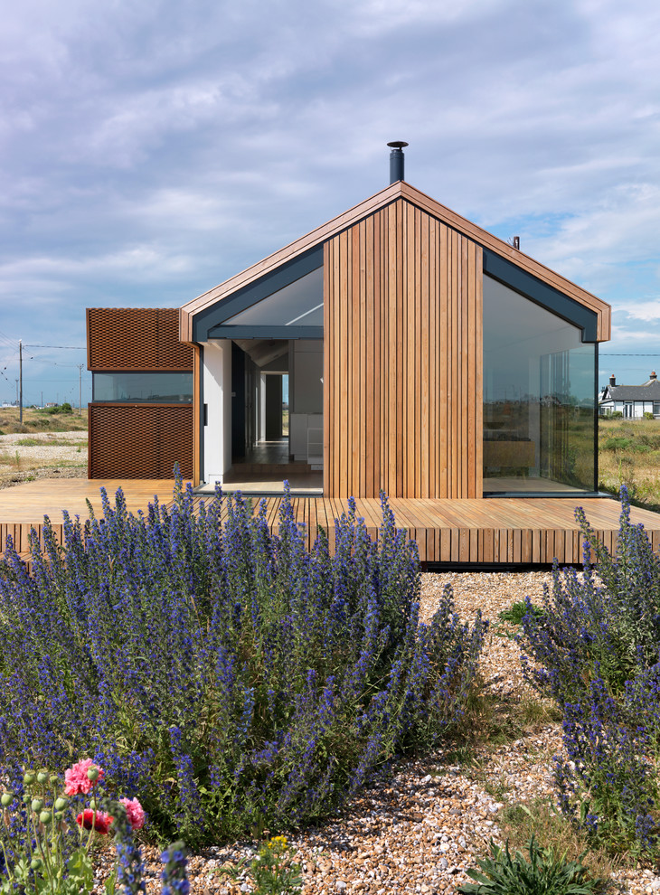 Réalisation d'une façade de maison design en bois de plain-pied avec un toit à deux pans.