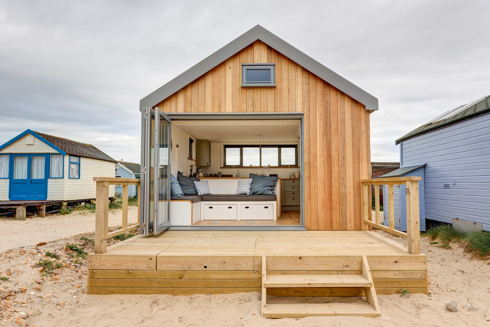Идея дизайна: маленький, одноэтажный, деревянный дом в морском стиле с двускатной крышей для на участке и в саду