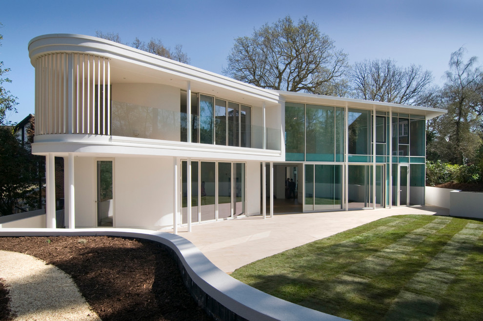 Foto della facciata di una casa bianca moderna a due piani con rivestimento in vetro