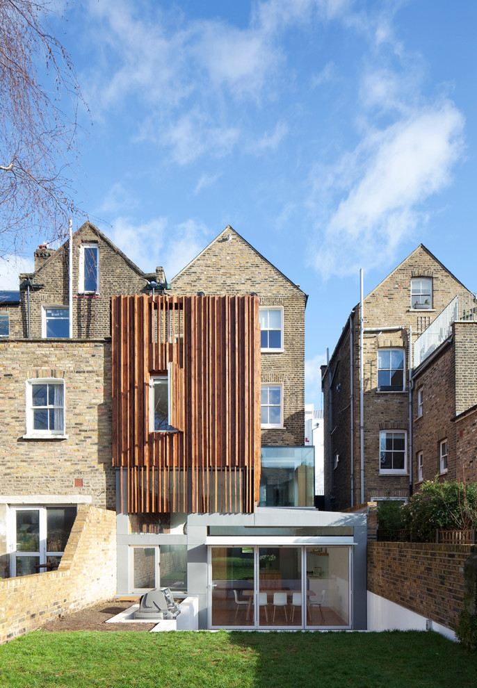 Cette image montre une façade de maison design en bois à deux étages et plus.