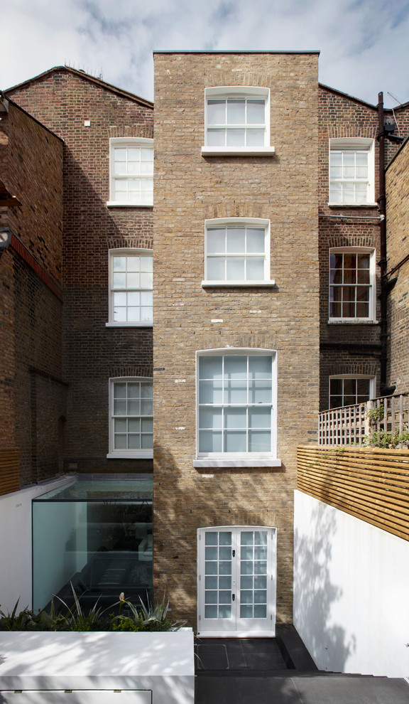 Design ideas for a traditional brick house exterior in London with three floors.