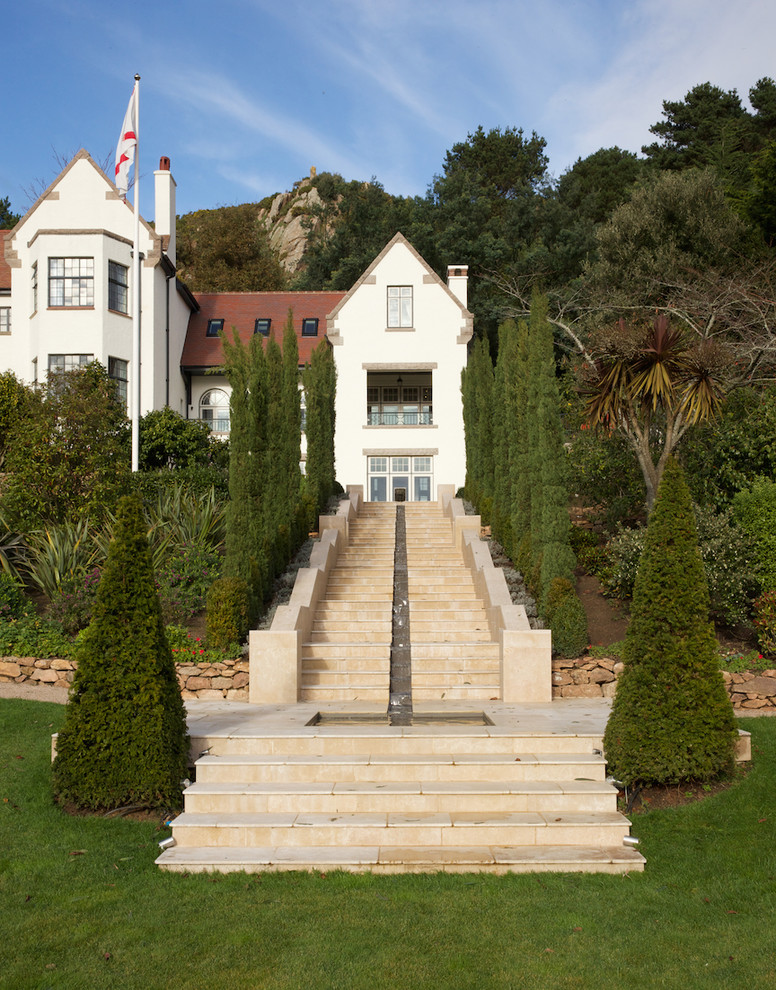 Diseño de fachada beige clásica de tres plantas con escaleras